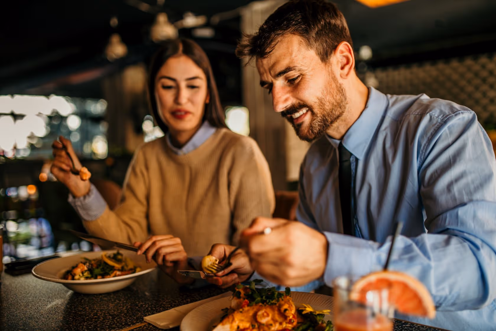 A man and a woman eating at a restaurant 