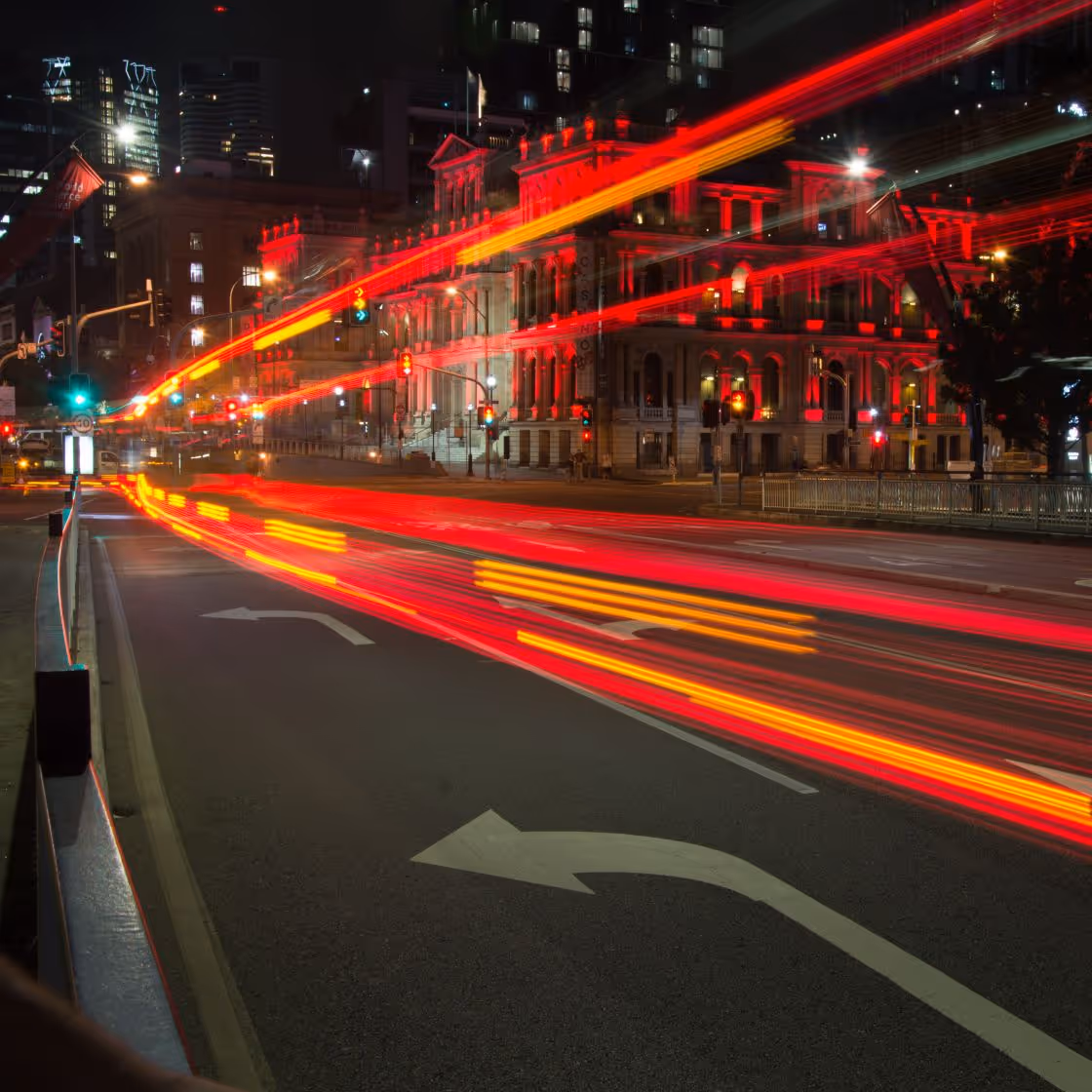 Red and orange light trail on city street at night
