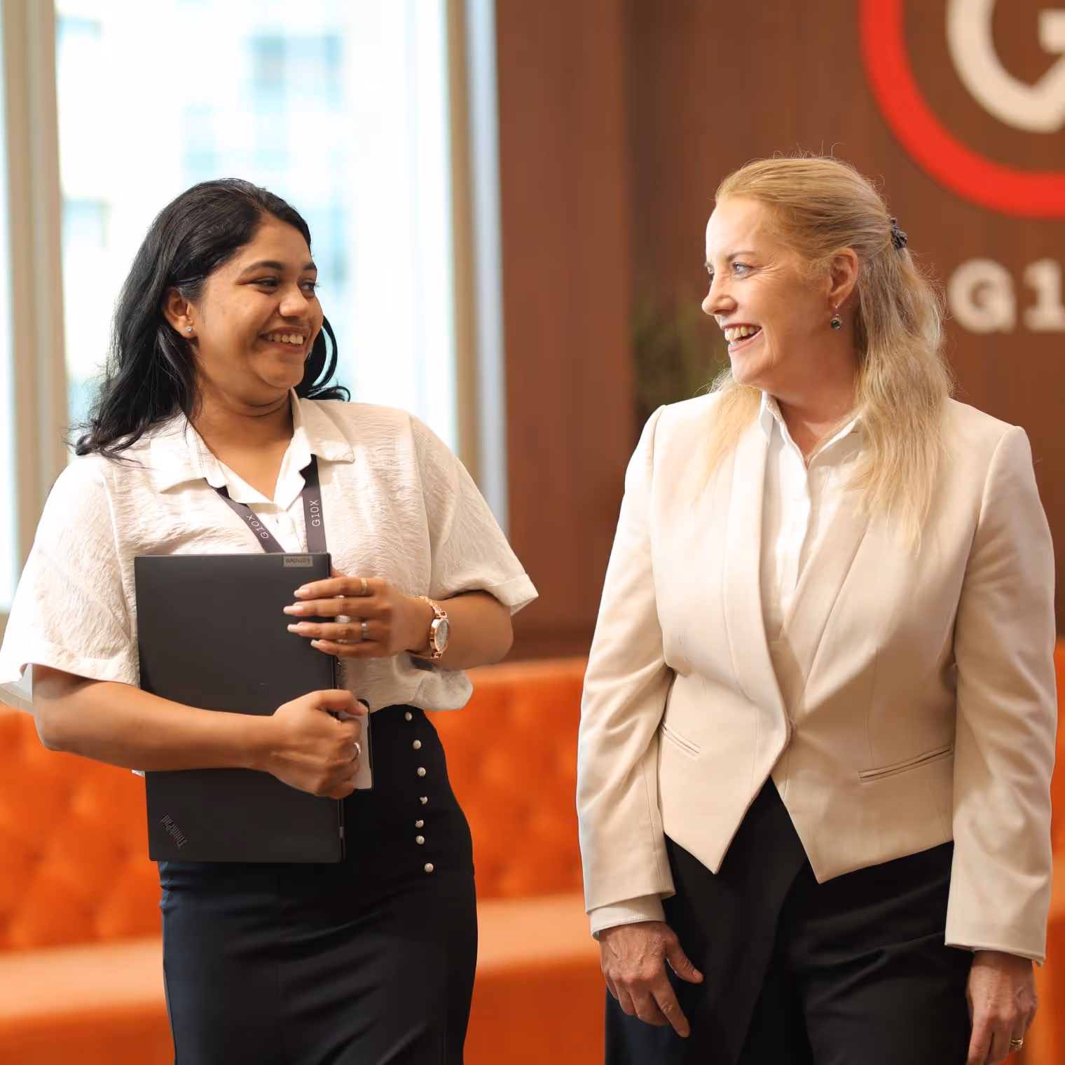 A young and an older woman walking in the office