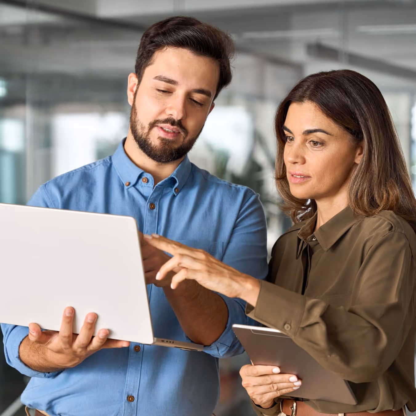 A man and a woman looking at something on a laptop