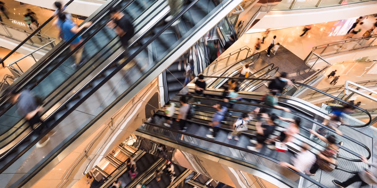 Busy mall with people on escalators