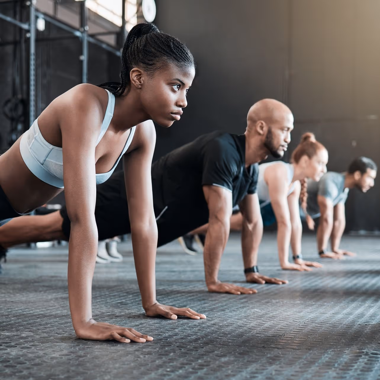 Group of people doing planks and looking ahead with determination
