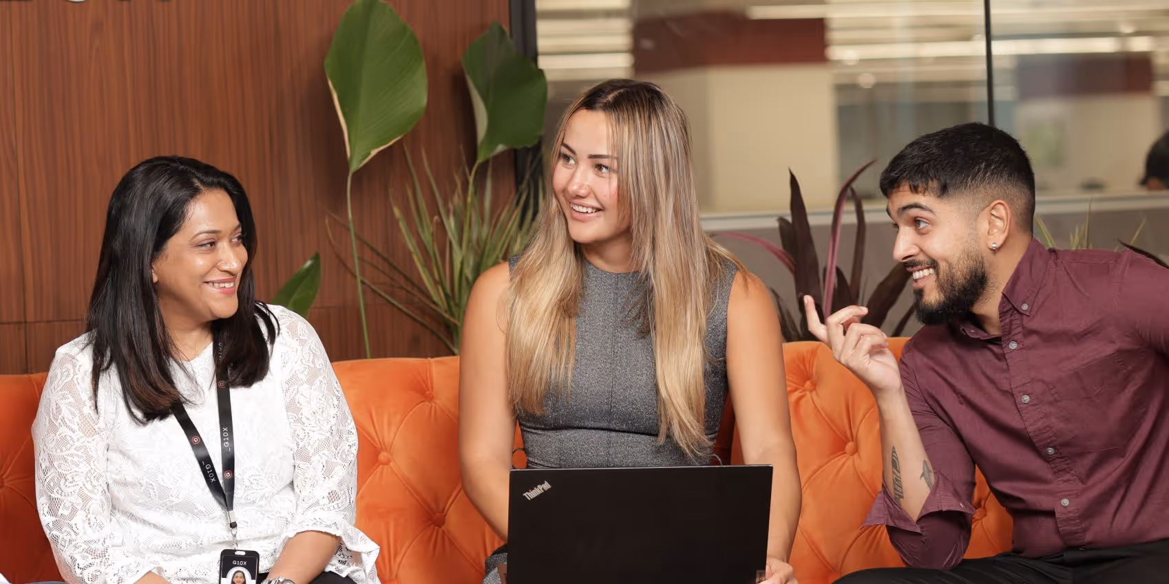 Two women and one man discussing something and laughing