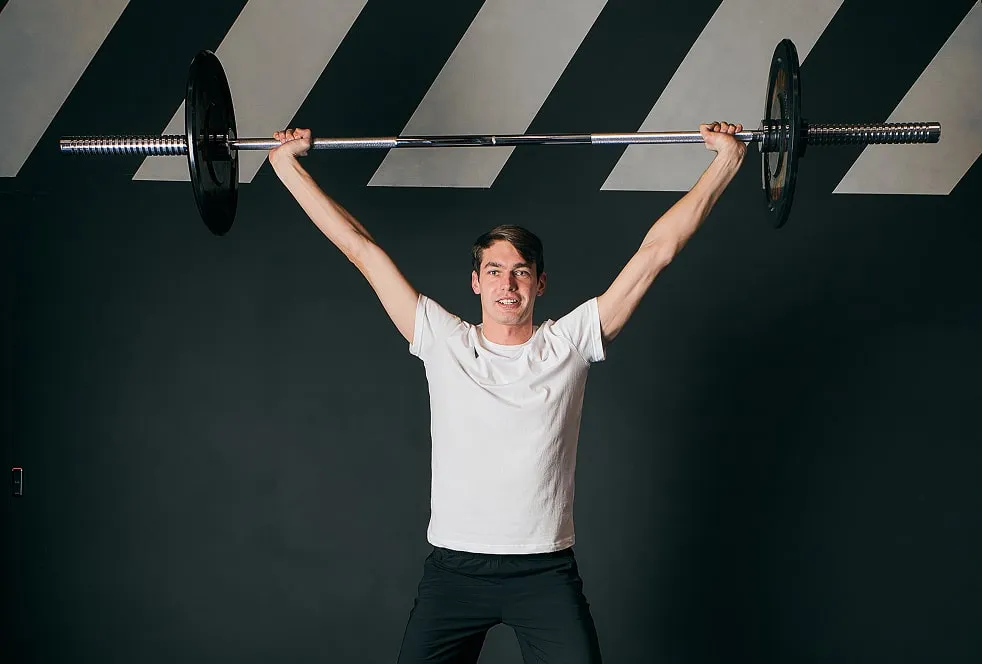 Спортсмен виконує вправу зі штангою, демонструючи силу та контроль. Це зображення ілюструє Розширений спортивний чекап, спрямований на поглиблений аналіз фізичних можливостей.