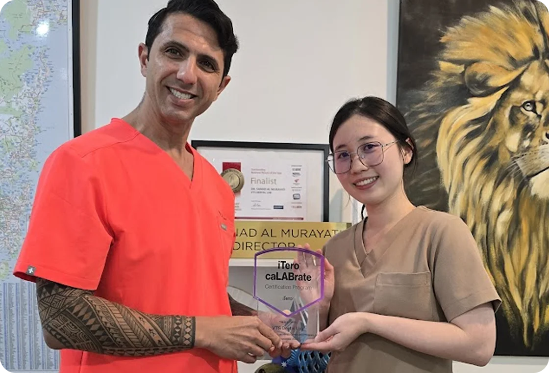 Two smiling healthcare professionals holding a transparent award plaque that reads 'iTero caLABrate Certification Program'.
