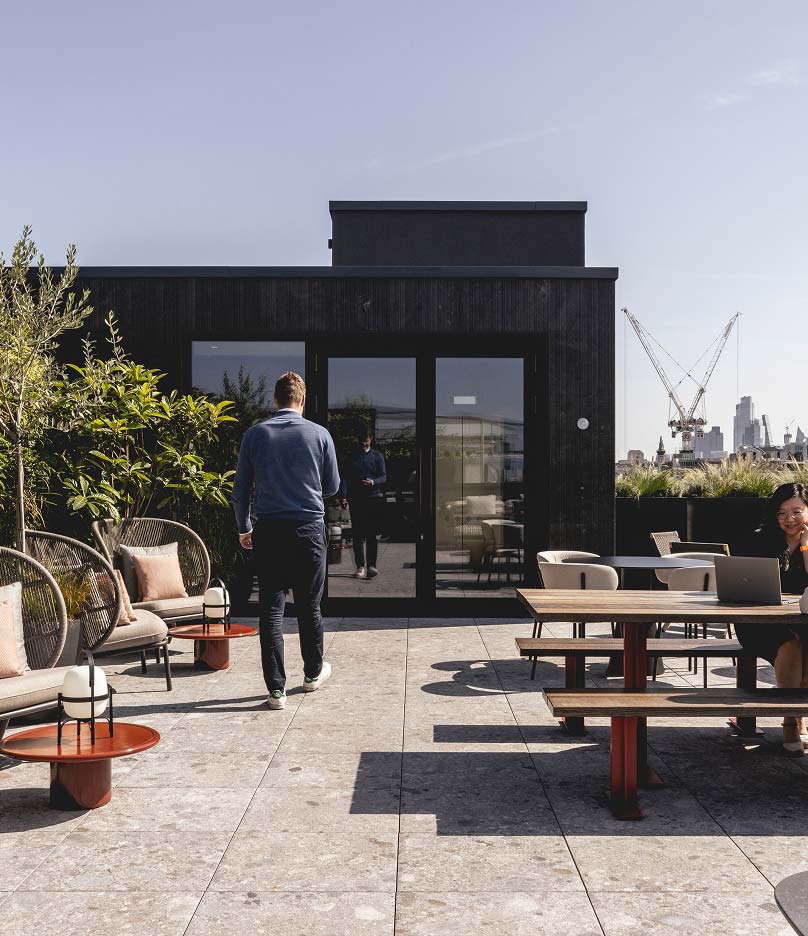 Man walking outside with chairs and tables around him