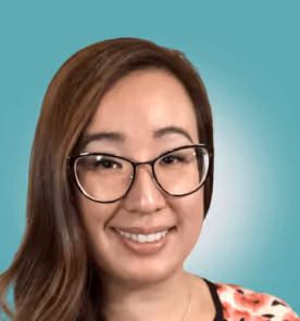 Smiling woman with glasses and long brown hair against a teal background.