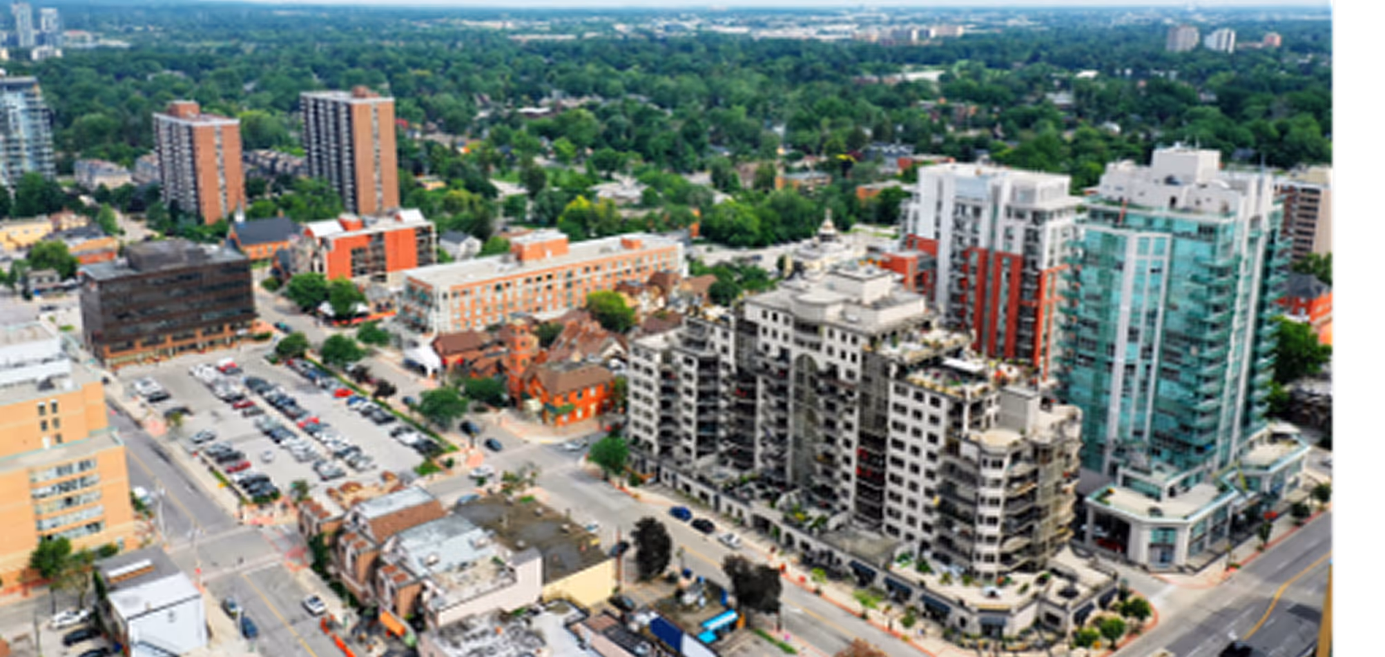 Aerial view of a cityscape featuring mid-rise residential and office buildings surrounded by greenery.
