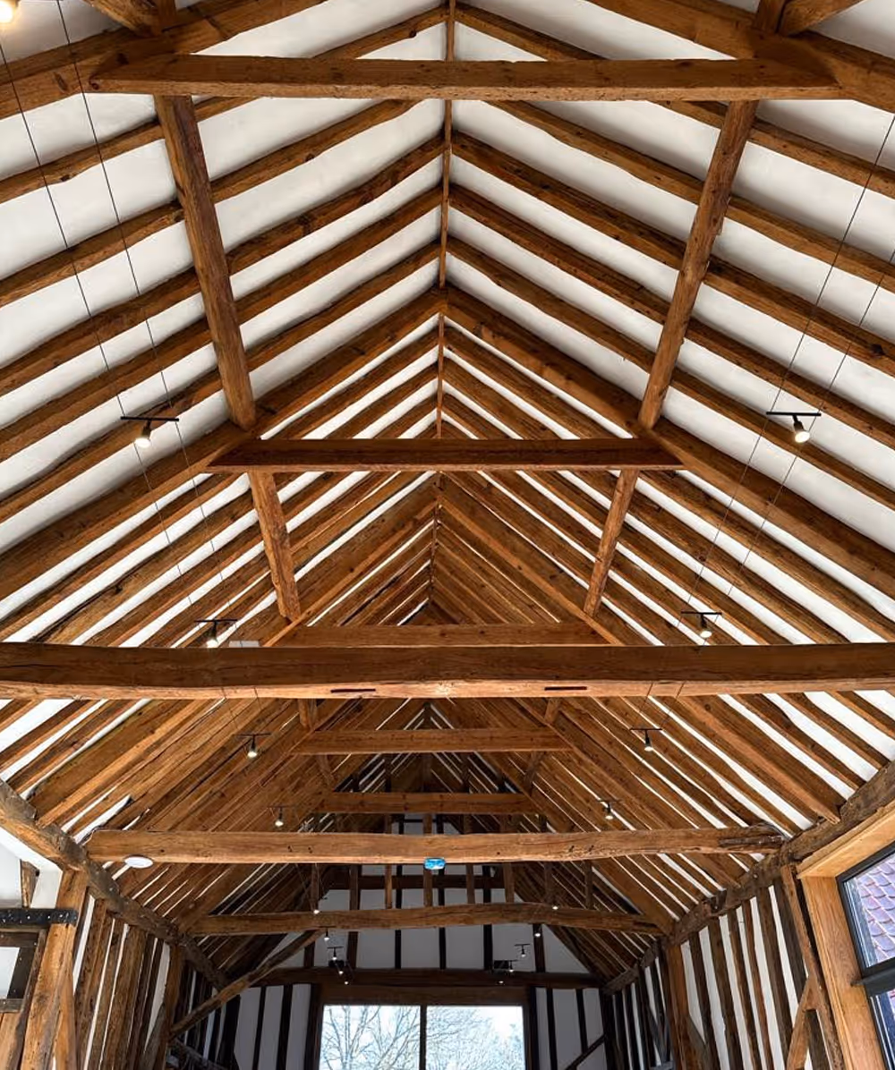 Interior view of a wooden vaulted ceiling with exposed beams and white panels. Province Group Construction.