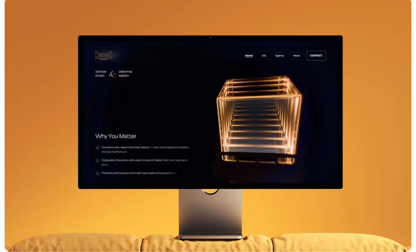 Desktop monitor on yellow couch showing a website with a glowing cube and text titled 'Why You Matter'.