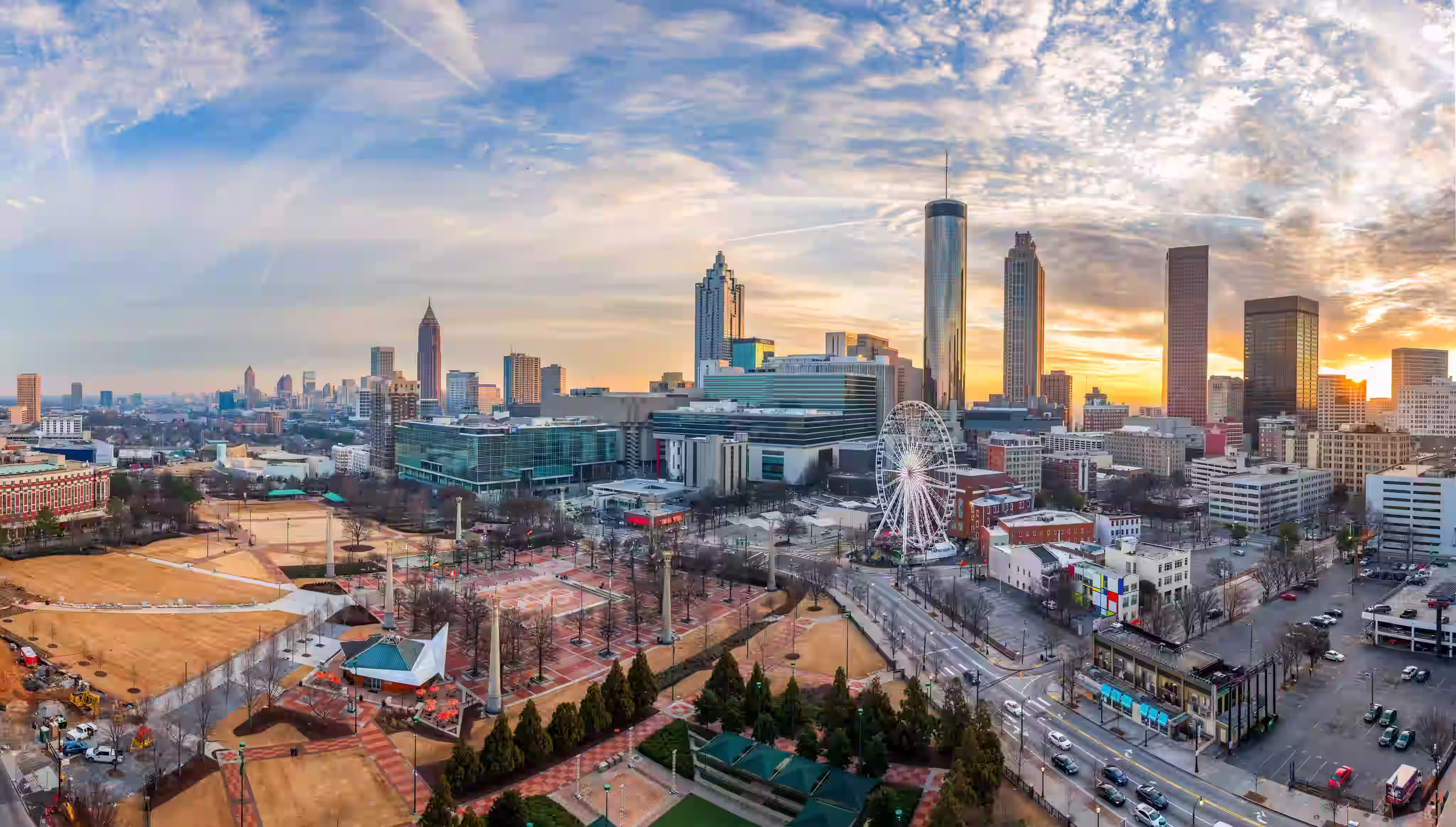 Panoramic view of downtown Atlanta, Georgia at sunset with skyscrapers and the SkyView Ferris wheel.