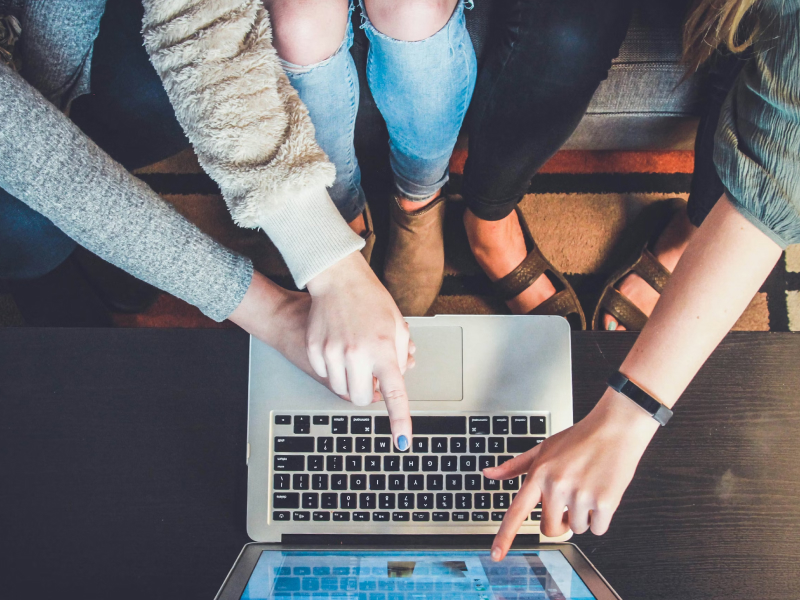 A group of people using a laptop