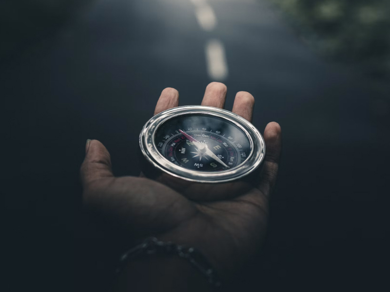 A compass being held in a hand
