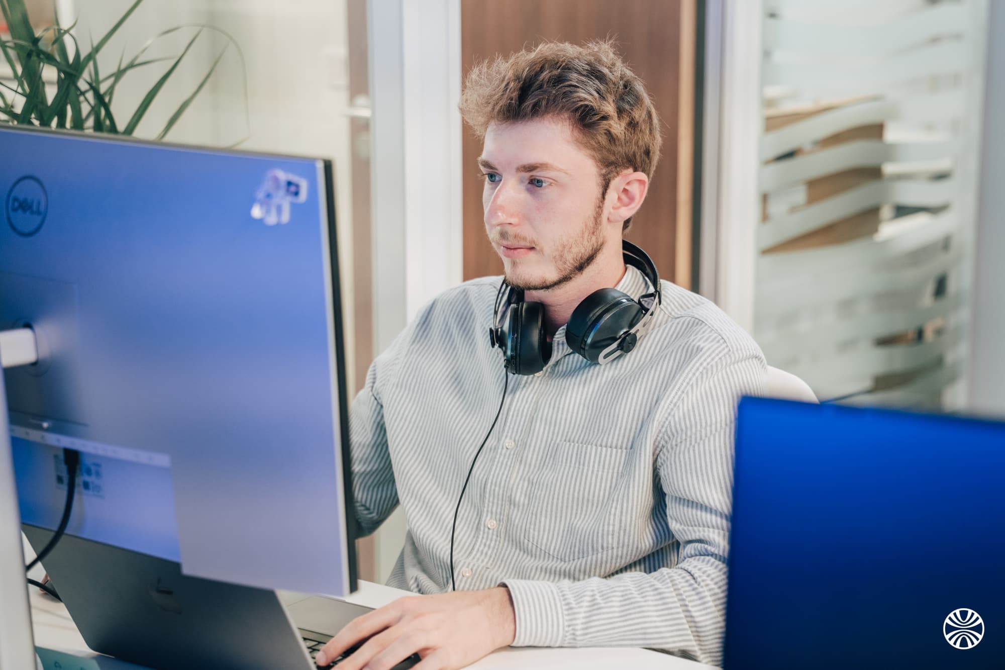 Un collaborateur au casque, concentré devant ses deux écrans
