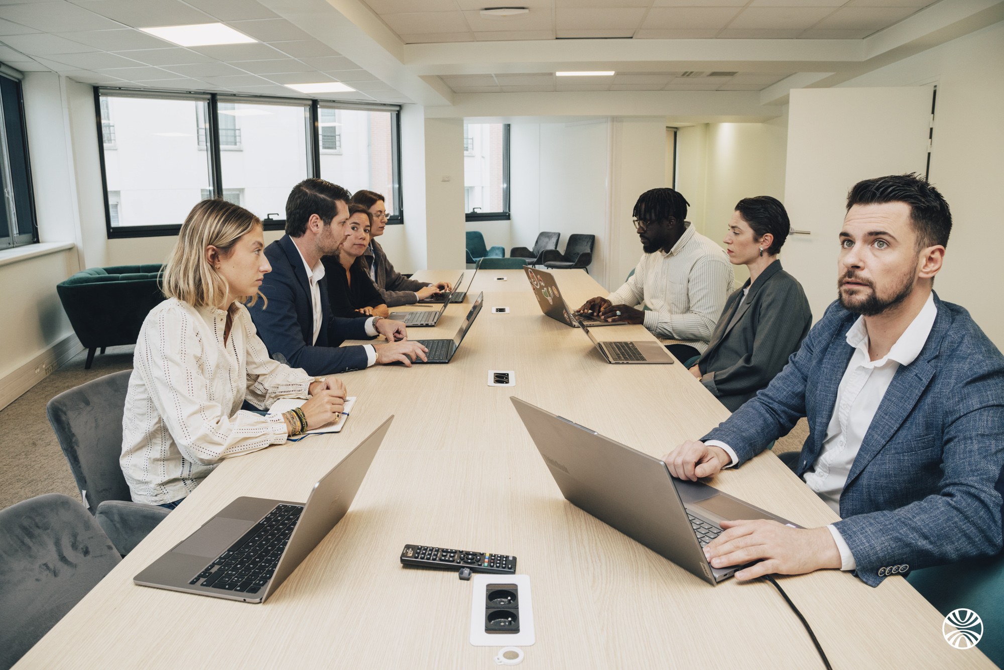 Réunion d'équipe Okuden autour d'une grande table de travail