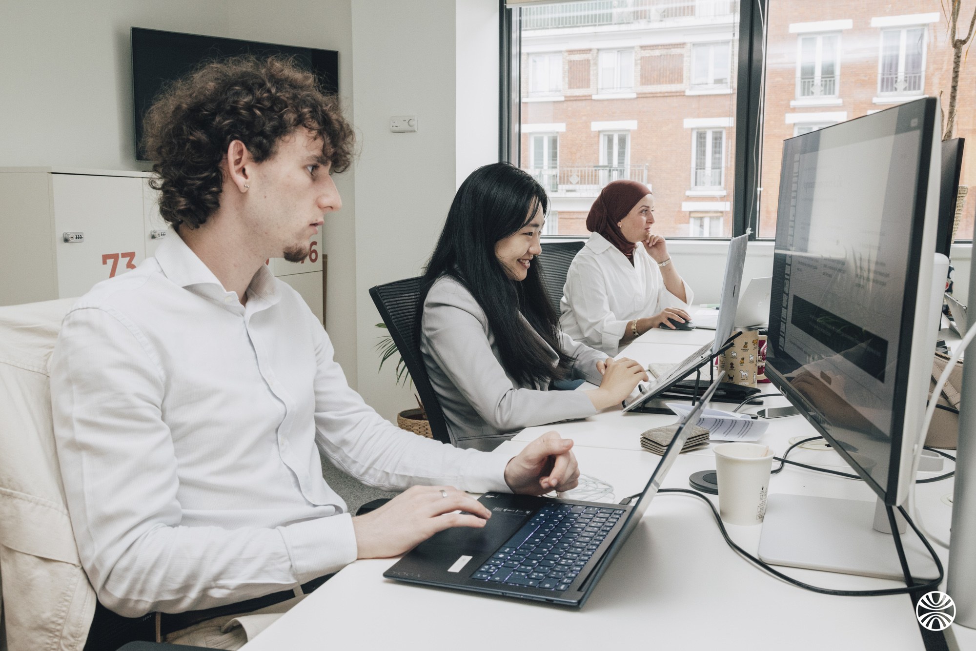 Trois consultants Okuden au travail devant leurs écrans