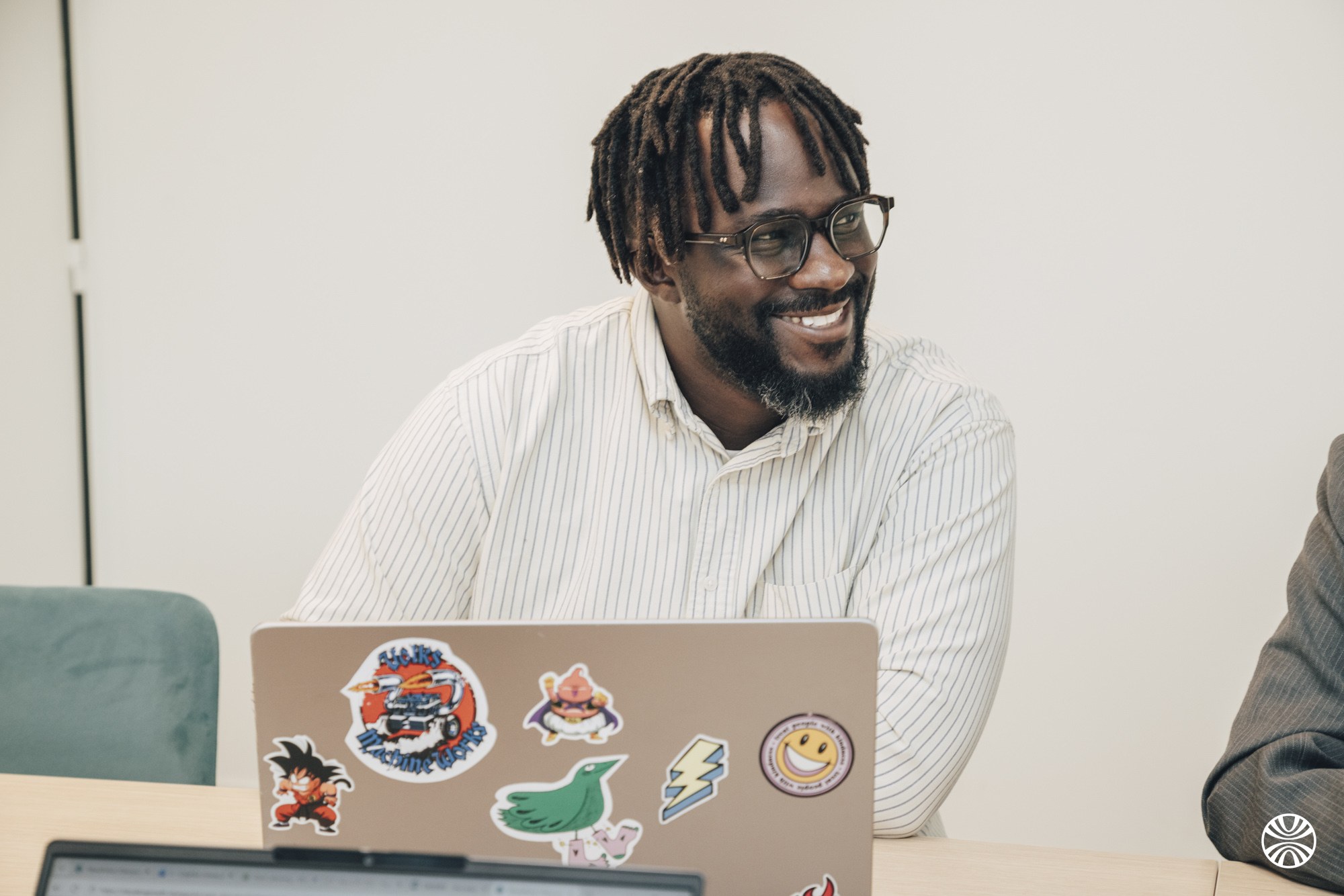 Consultant Okuden souriant devant son ordinateur portable