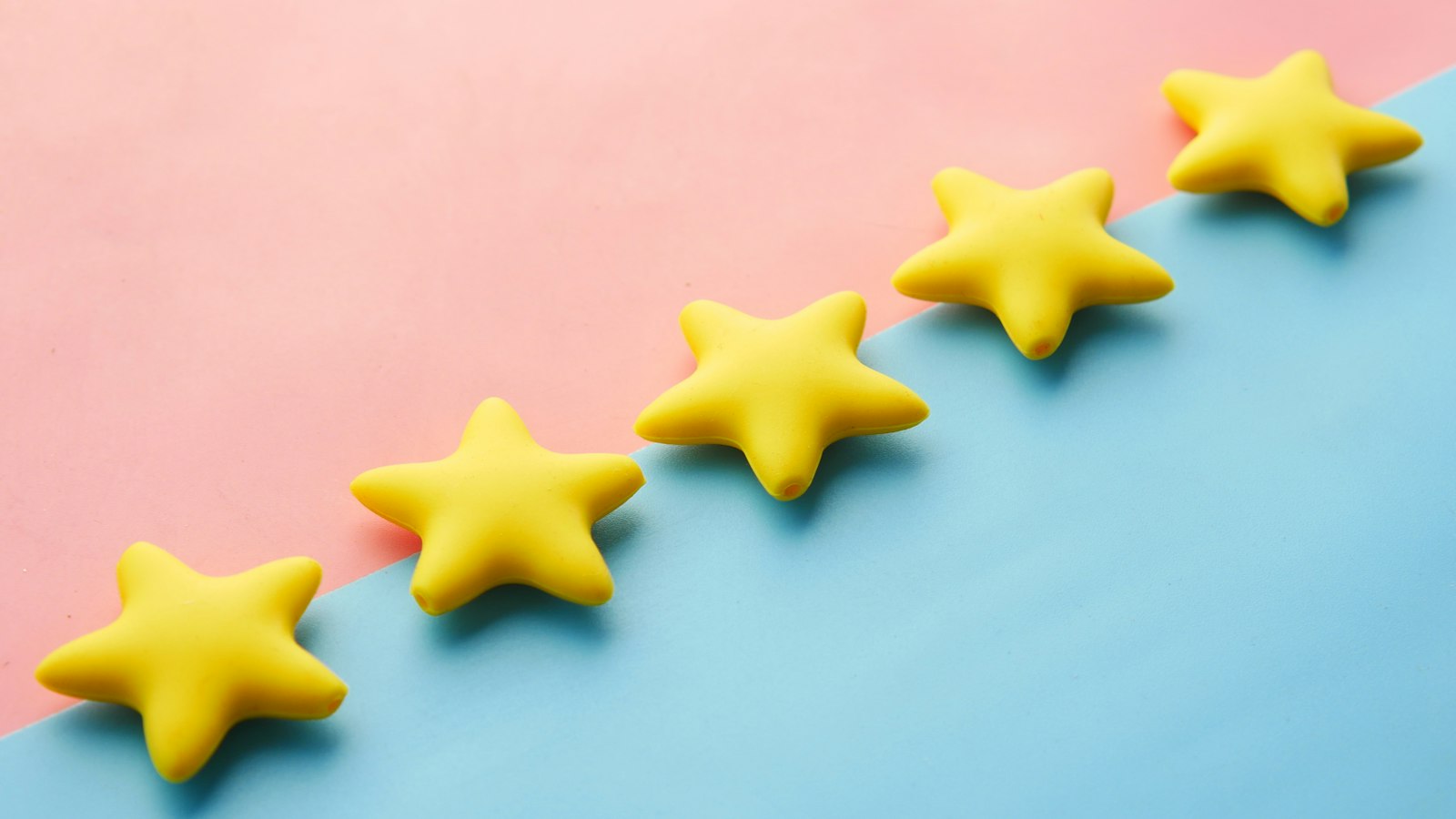 Rangée de cinq étoiles jaunes sur fond bleu et rose