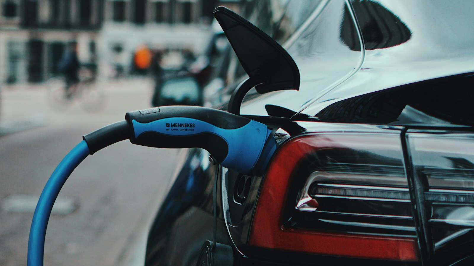Câble de recharge branché sur une voiture électrique dans une rue de ville