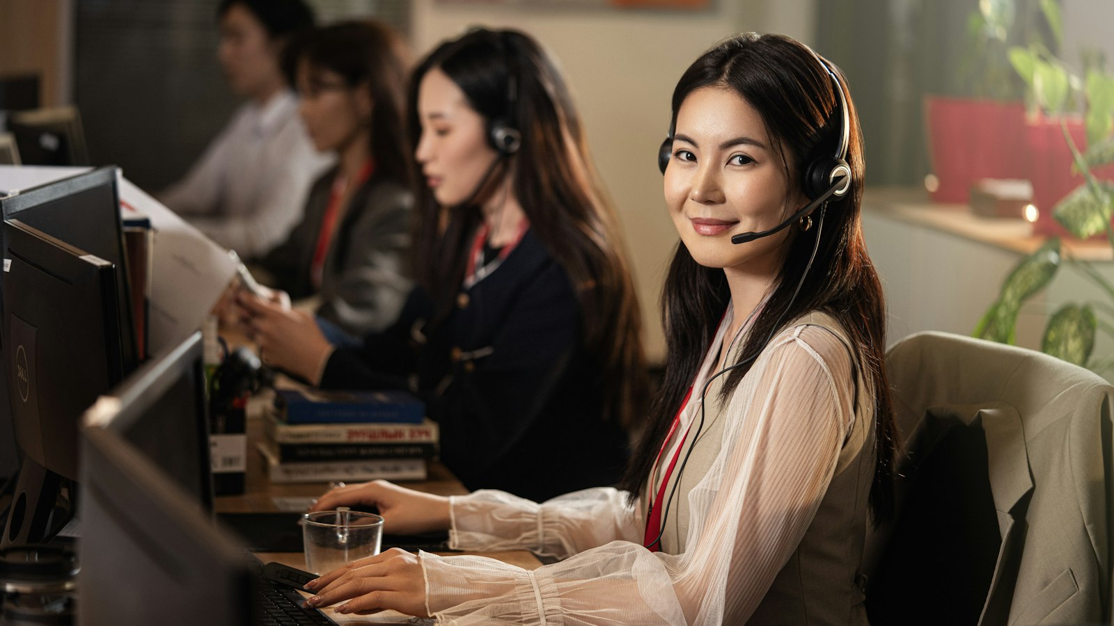 Conseillère clientèle avec un casque, assise devant un ordinateur