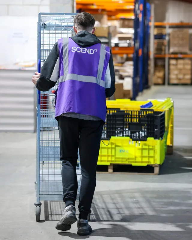 Man pushing crate through warehouse