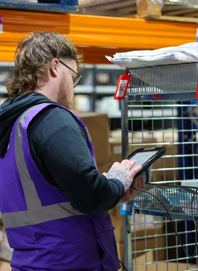 SCEND team member checking an order on a handheld scanner
