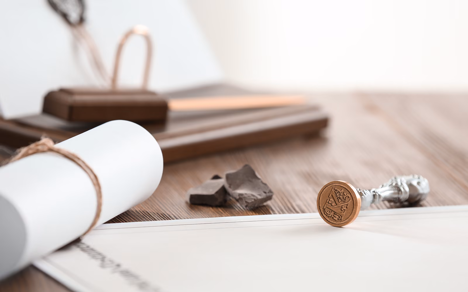 Siegelstempel und ein zusammengerolltes Dokument auf einem Holztisch.