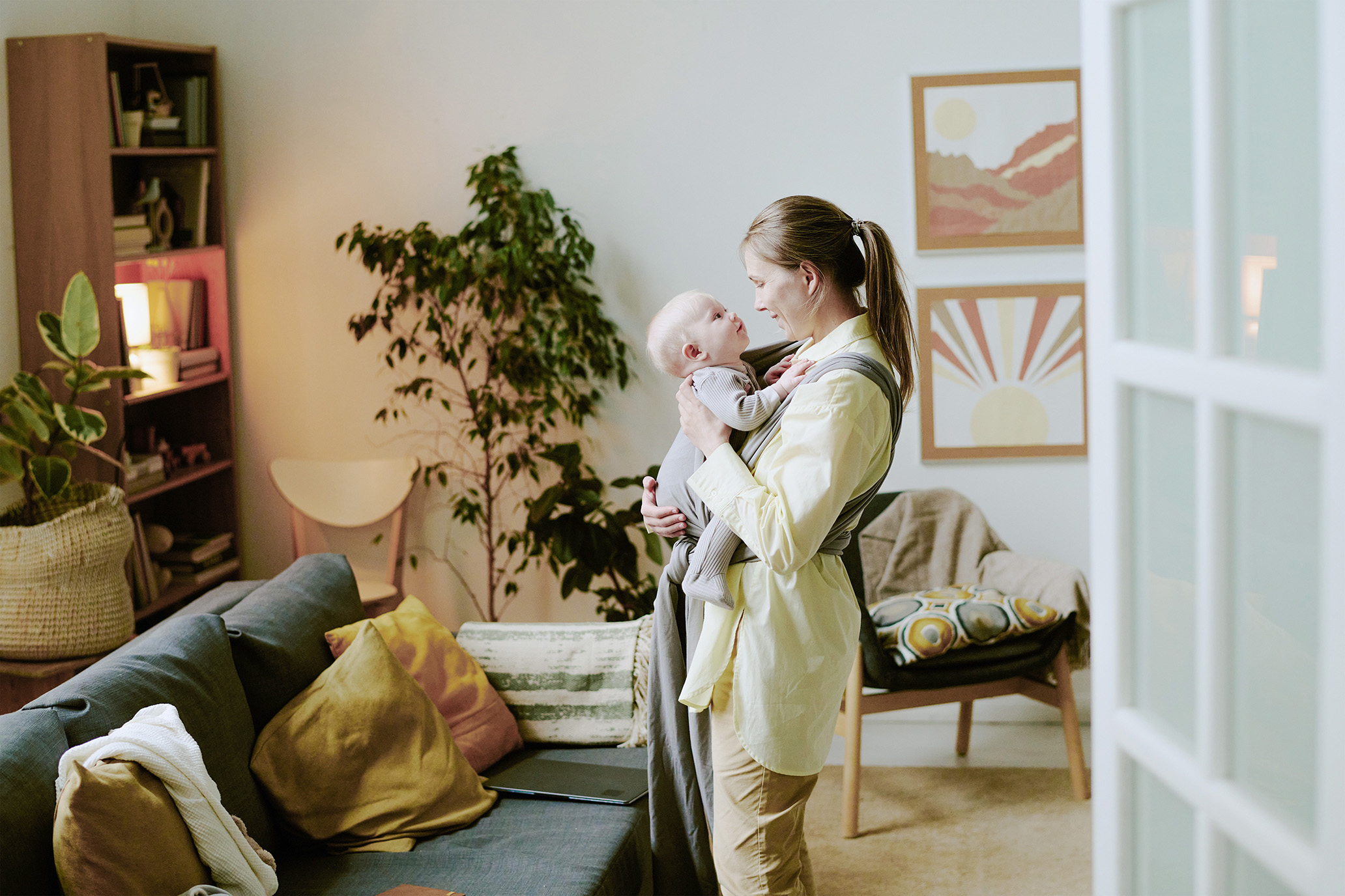 Kvinde står med datter i stue