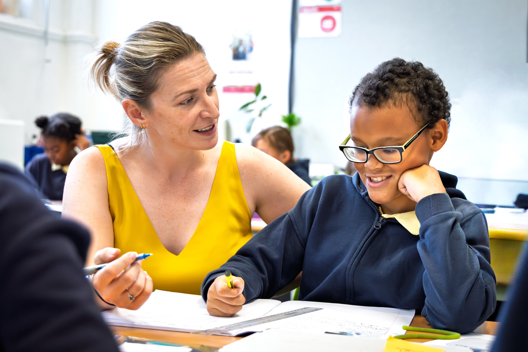 A teacher working with a student at The Belham