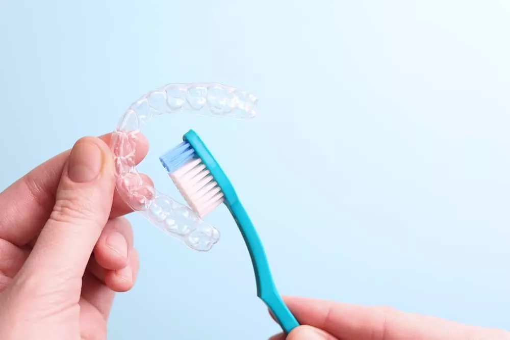 Cleaning Invisalign retainer with toothbrush