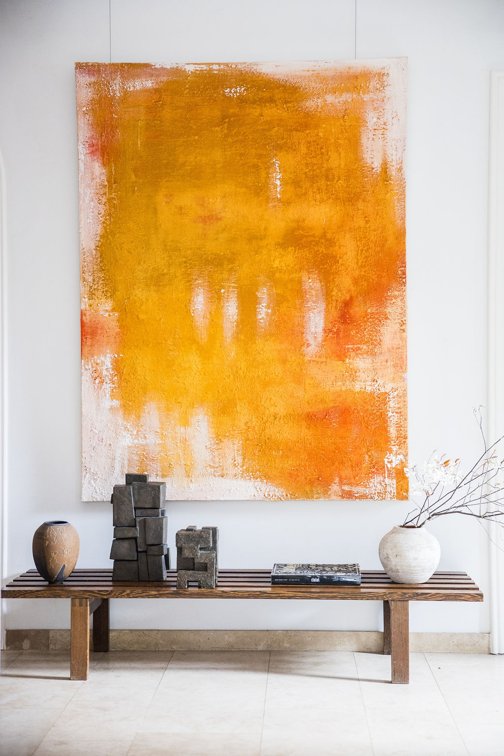 A powerful abstract composition rendered in rich warm orange and white tones using raw pigments, created by Belgian artist Catherine van Pottelsberghe. This one-of-a-kind painting explores texture, depth, and mineral color, evoking landscapes, matter