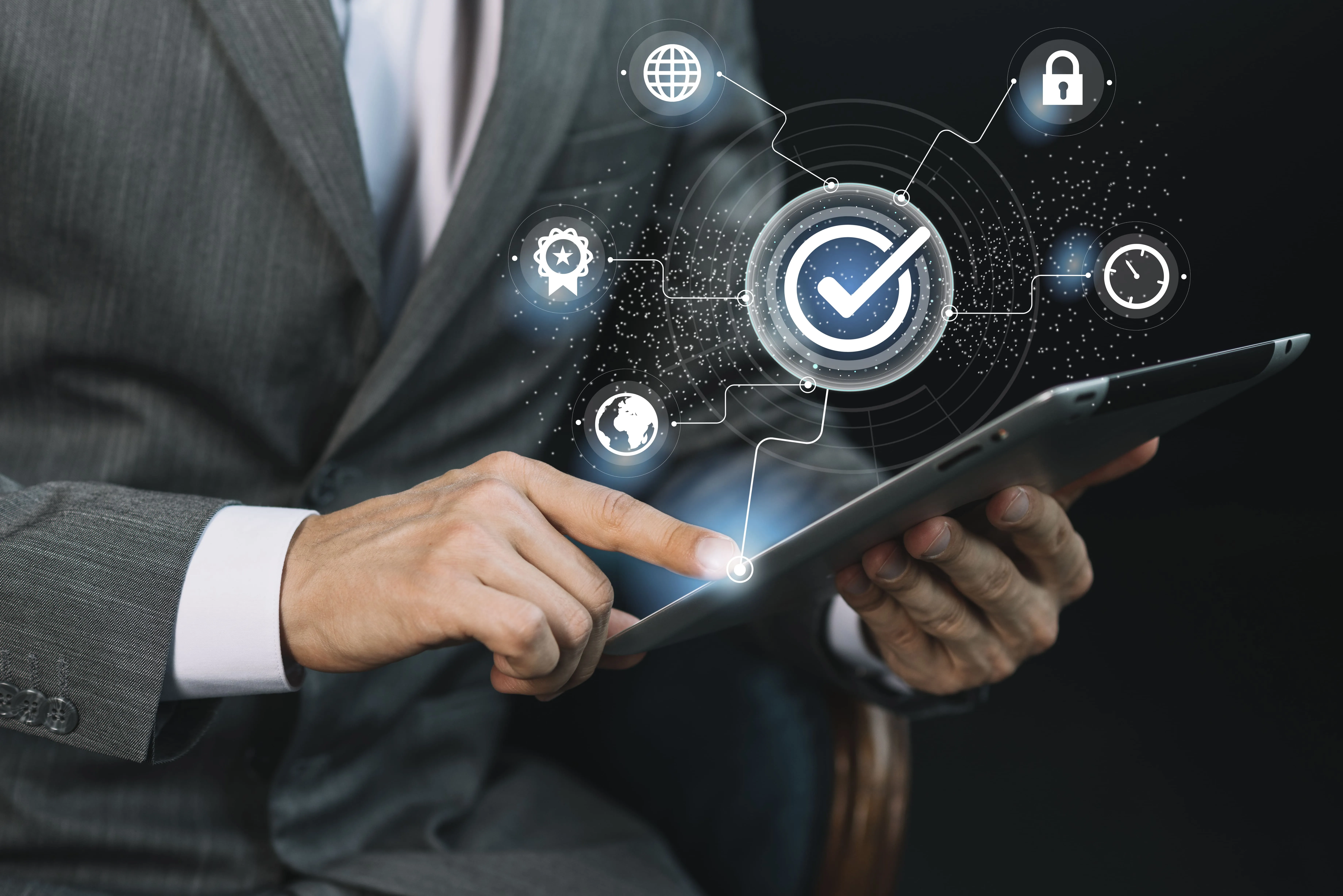 Businessman in suit using a tablet with digital quality control icons including a checkmark, globe, lock, clock, and badge.