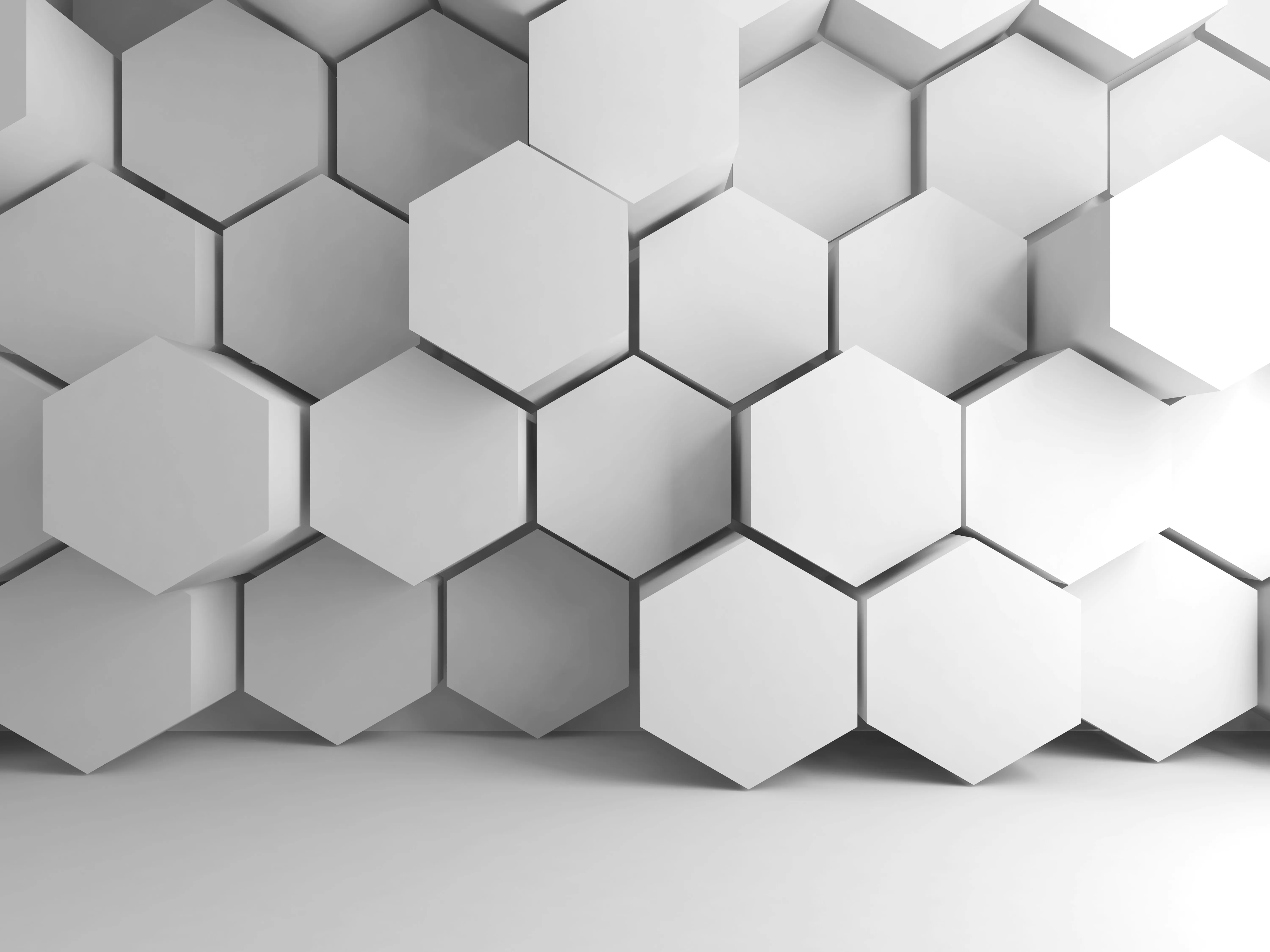 Three-dimensional white hexagons arranged in a honeycomb pattern with shadows creating depth.