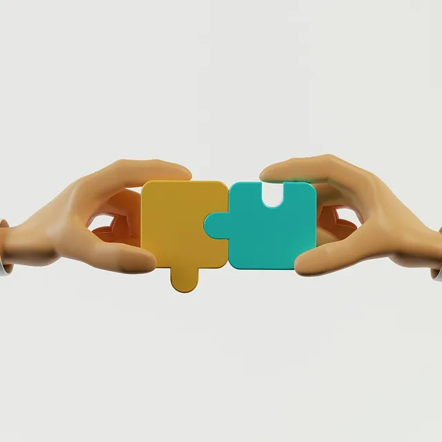 Two hands each holding a puzzle piece, fitting a yellow and blue piece together against a plain background.