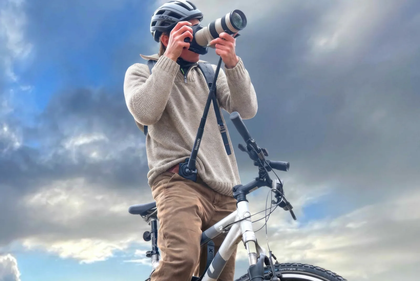 Cyclist shooting with a camera supported by Steadify while seated on a bike