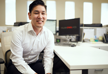 A corporate photograph of research analysis director Derek Higa.