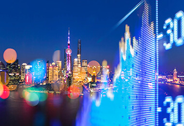 An image of the a city at night with stock charts overlayed on top.