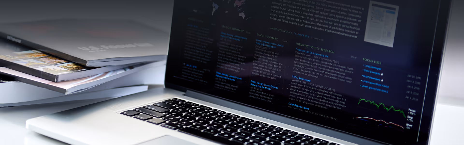 An image of a Apple Laptop and William O'Neil Stock Books on a table.
