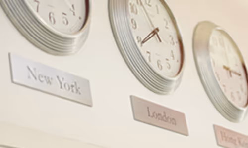 An image of clock on the wall showing different cities time.