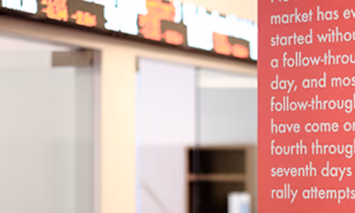 An image of the Boston office main room with a ticker running on the wall.