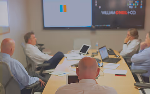 An image of several team members having a meeting sitting at a conference room.