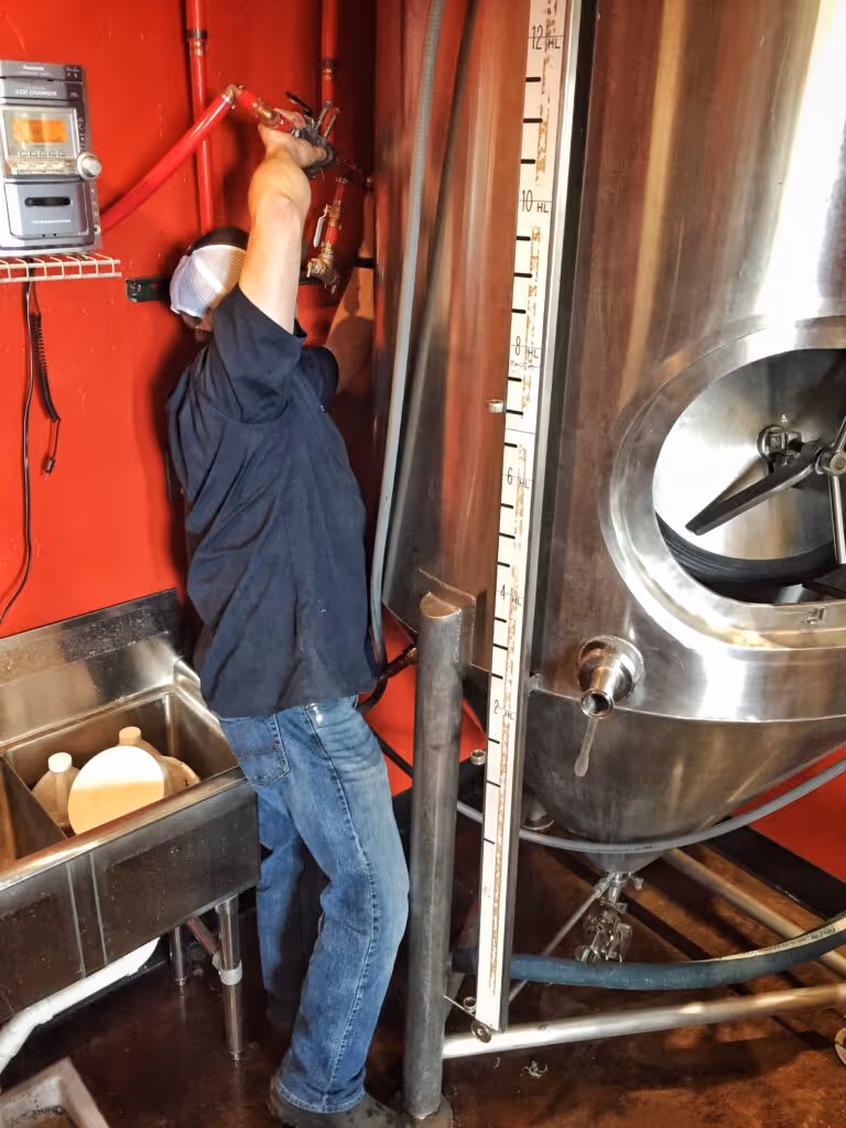 A person filling the sour fermenter.