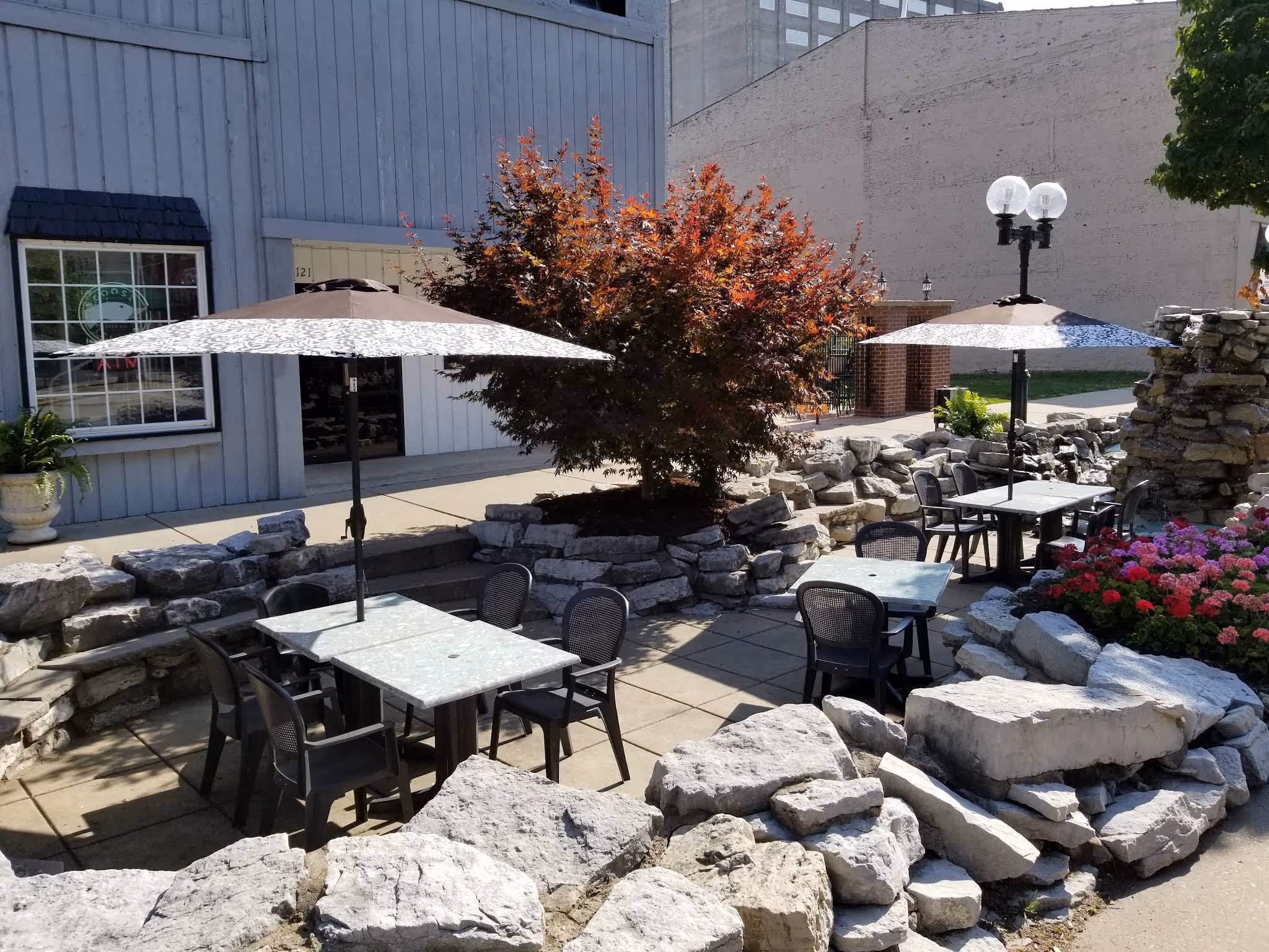 A rock garden with a tree and a patio set.