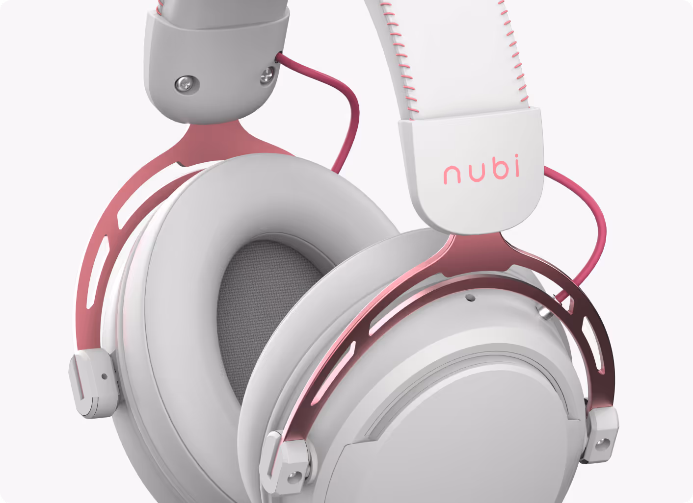 Close-up of white over-ear headphones with pink metal frame and white leather headband stitched with pink thread, featuring the brand name 'nubi'.