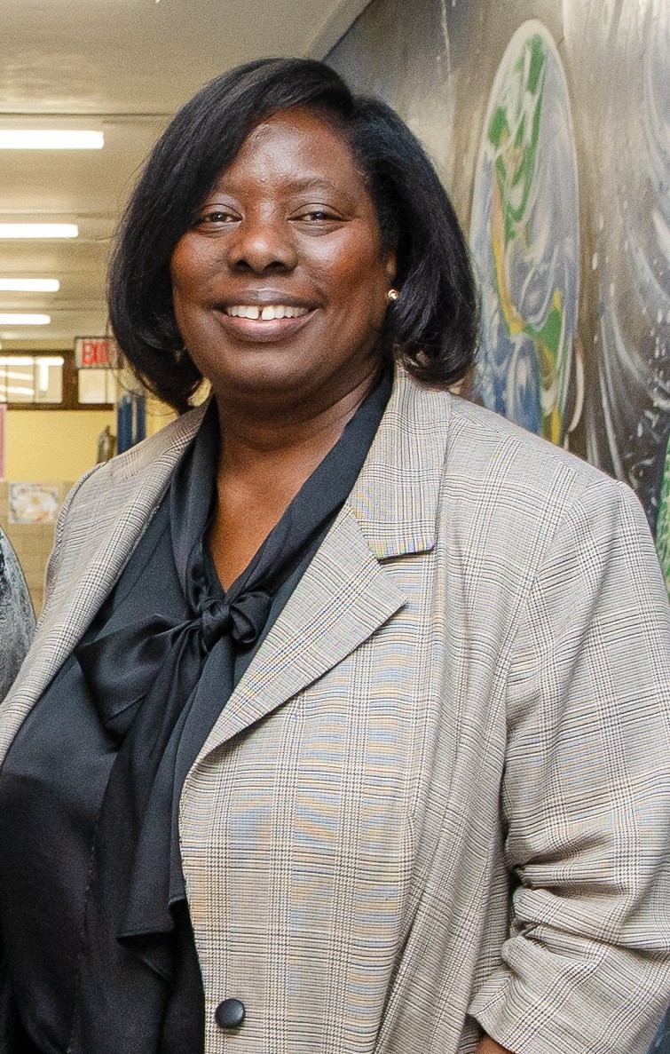 Principal of P.S. 107 smiling in school hallway