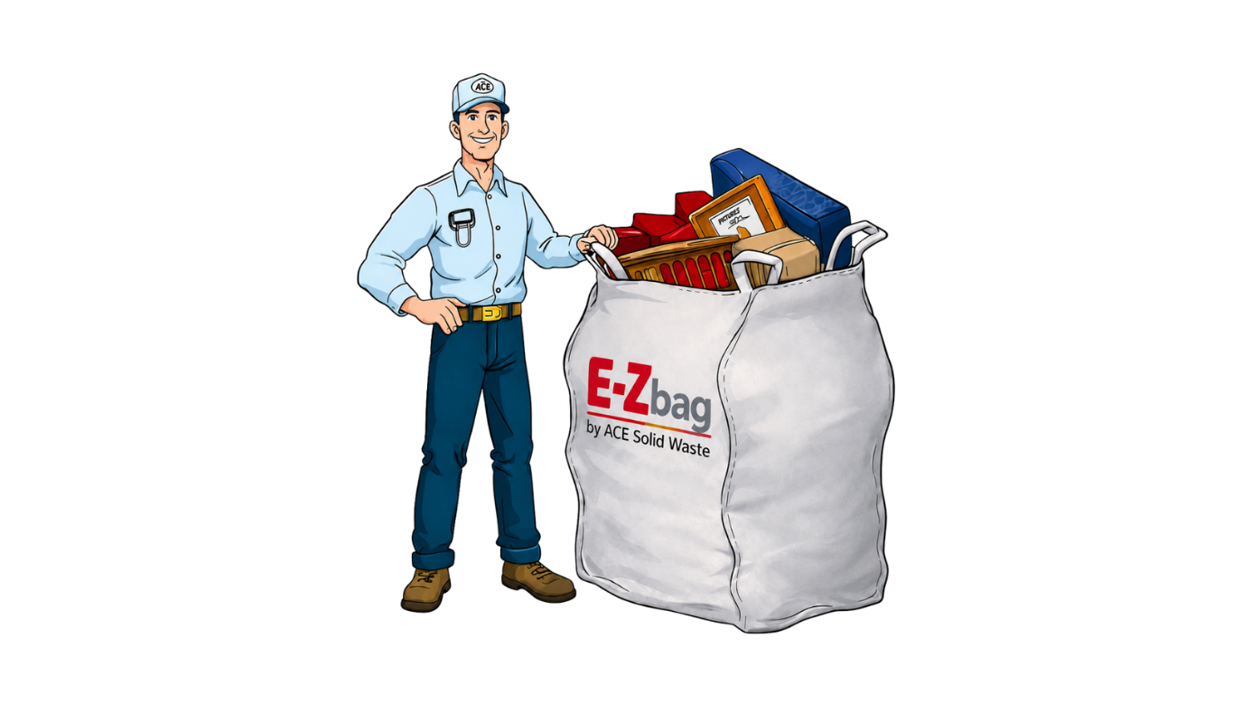 Man in work clothes stands next to a large white E-Z bag filled with household items.