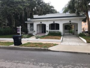 Florida home with white stucco exterior and green tile roof