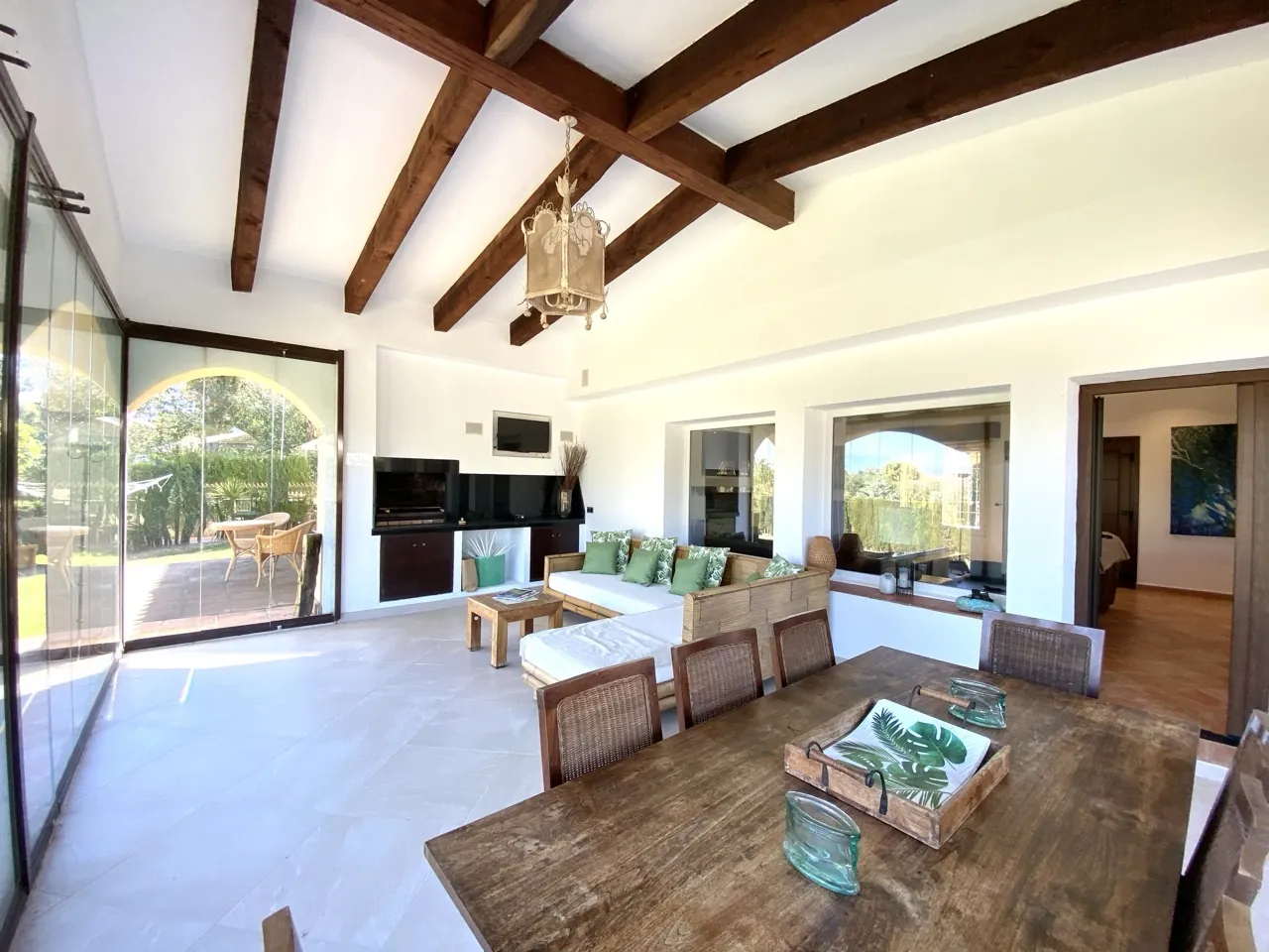 Living room with exposed wooden beams, fireplace and garden access