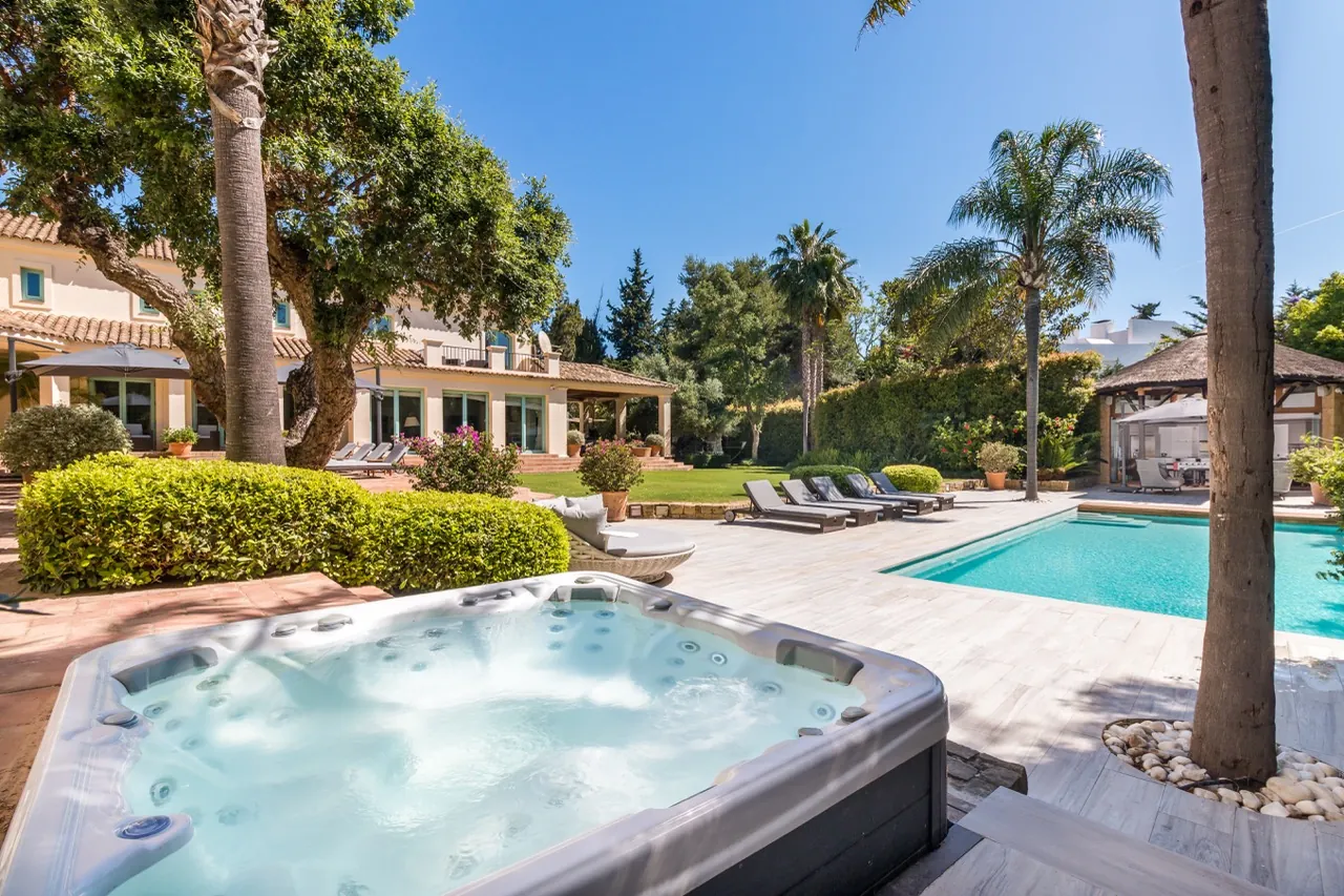 Swimming pool with palm trees, terrace and villa exterior