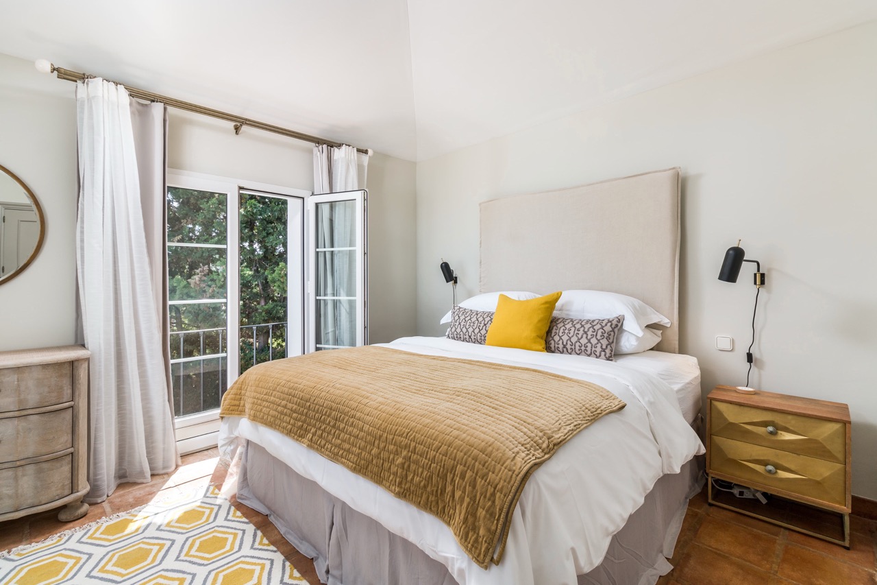 Bedroom with double bed, wooden flooring and garden-facing doors